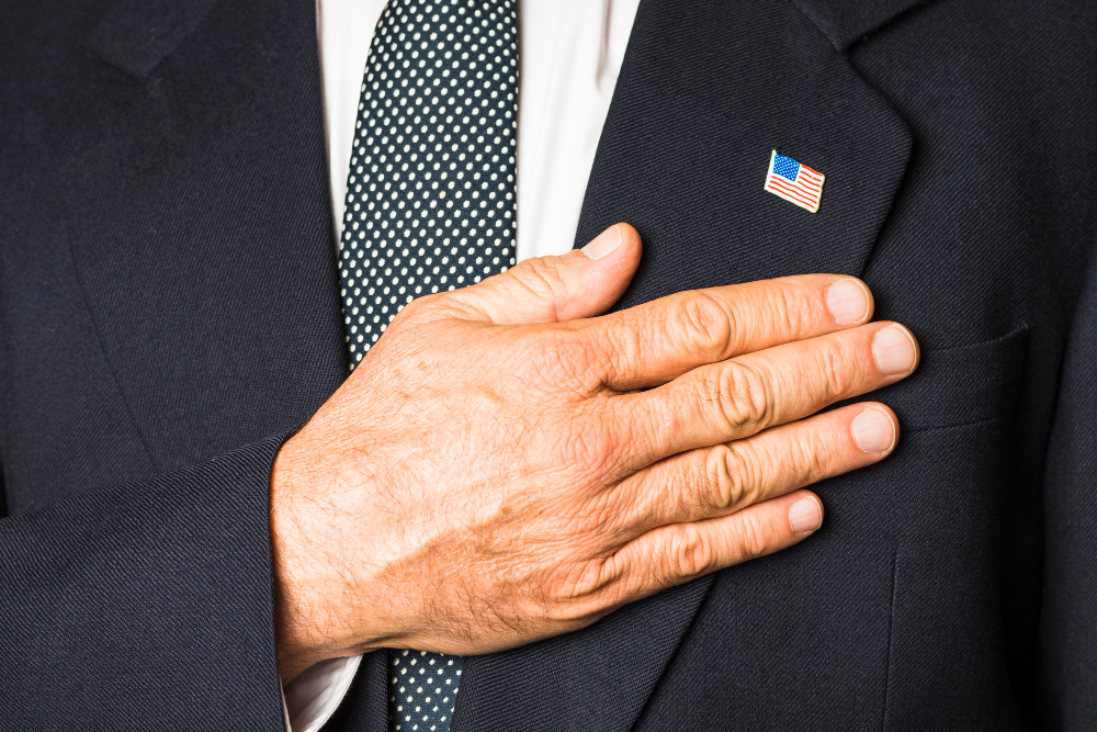close-up-patriotic-man-with-usa-badge-his-black-coat-touching-hand-his-chest